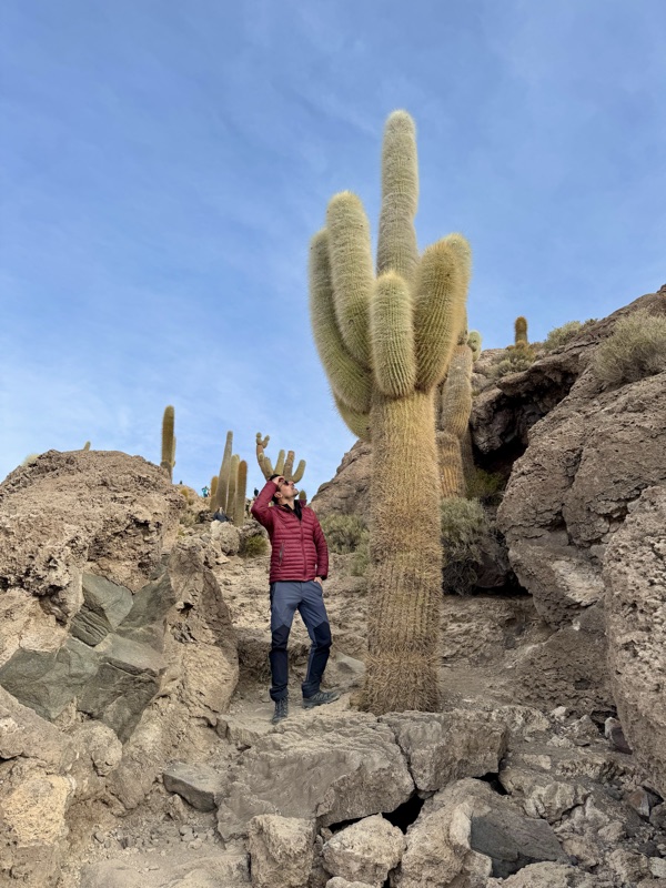 Standing on the rocks beside a giant cactus on Isla Incahuasi, in the middle of the salt flat