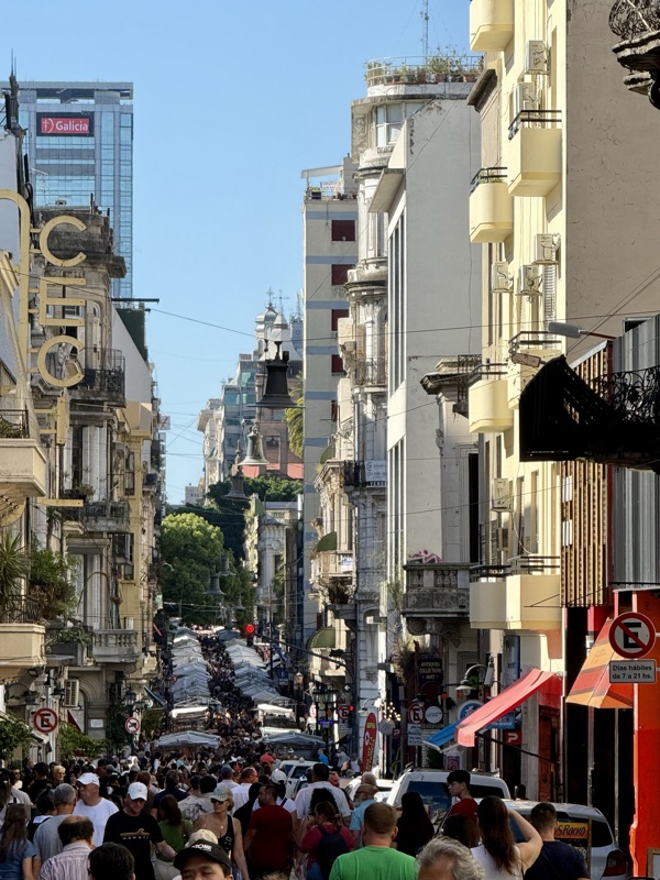 A busy street in San Telmo lined with old buildings and balconies