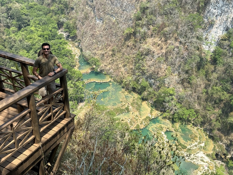 The turquoise limestone pools of Semuc Champey seen from a wooden lookout high above the jungle